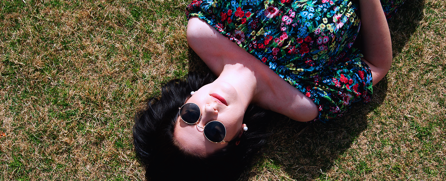 Female student relaxing while laying on the grass 