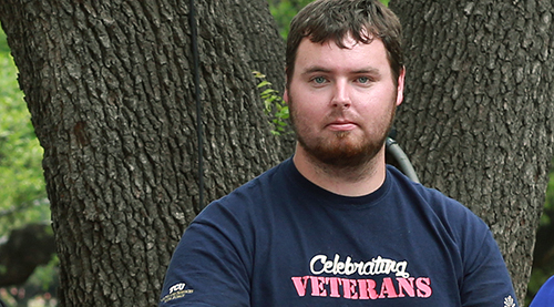 veteran student in front of tree