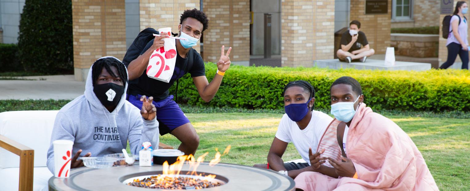 students gathered around a fire pit in the commons