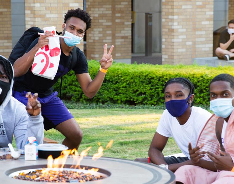 students gathered around a fire pit in the commons