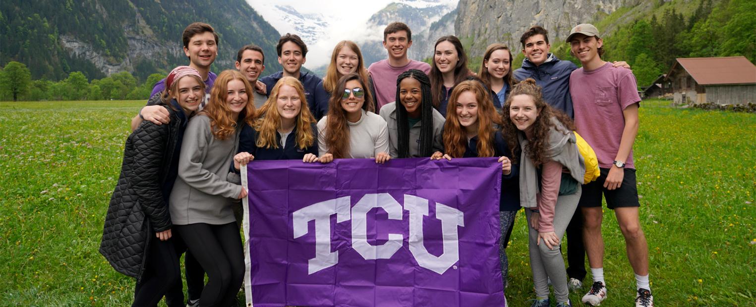 honors college students pose with a TCU flag while studying abroad 