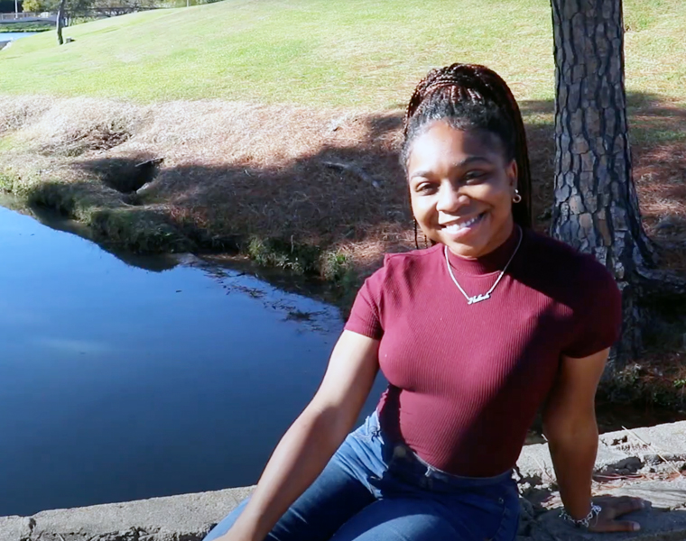 Queen sitting near a body of water on the TCU campus