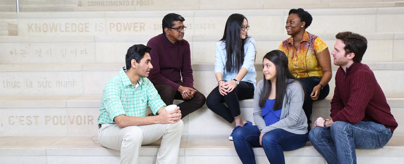 Dr Akkaraju with students on the steps inside the library