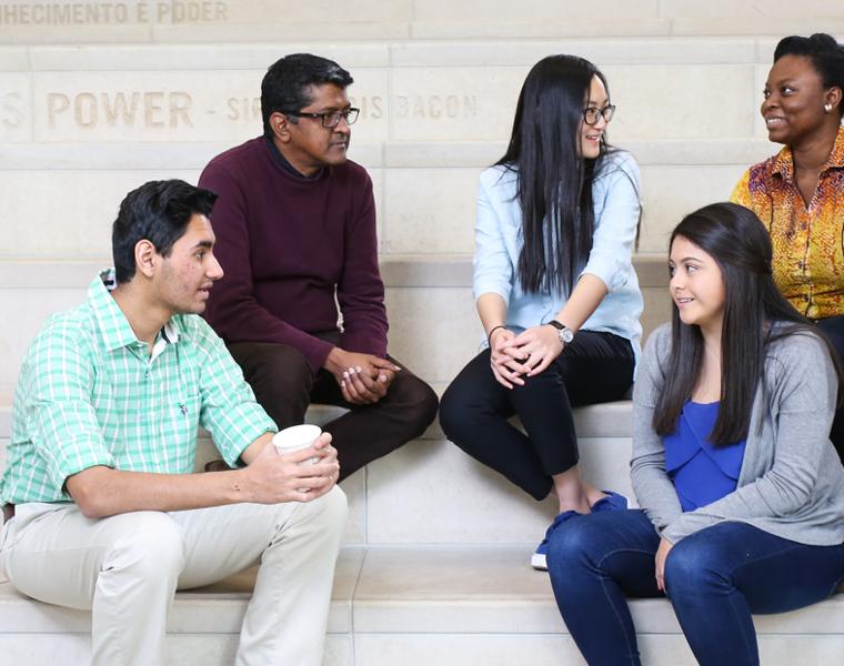 Dr Akkaraju with students on the steps inside the library